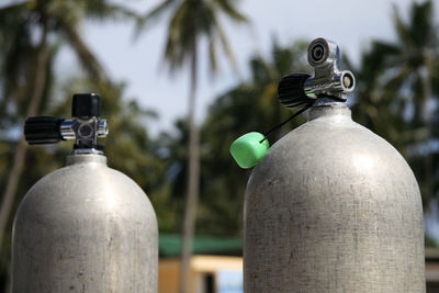 Close-up of cylinders against trees