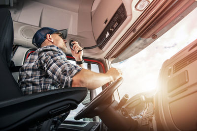 Side view of man driving car