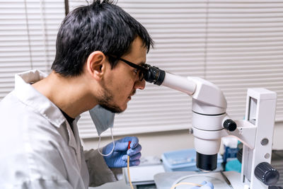 Male scientist using microscopy in laboratory