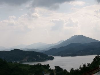 Scenic view of river and mountains against sky