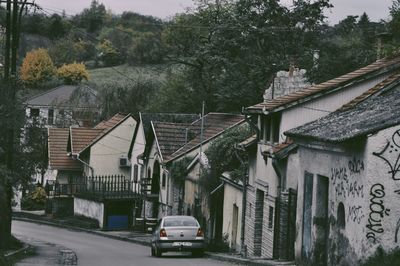 Houses by street and buildings in city