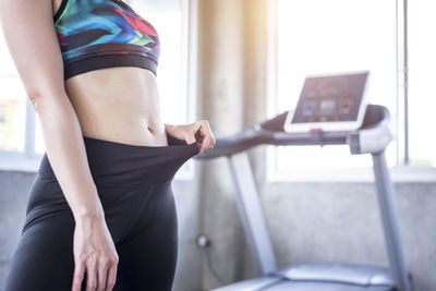 Midsection of woman stretching pant in gym