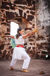 Full length portrait of young woman jumping