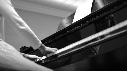 Close-up of man sitting on piano