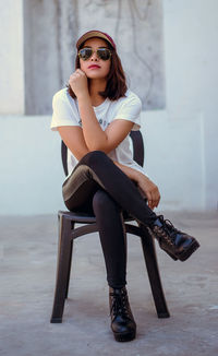 Portrait of young woman sitting in sunglasses