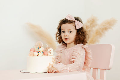 Portrait of a charming little girl with a cake during a birthday celebration