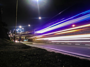 Light trails over illuminated street at night