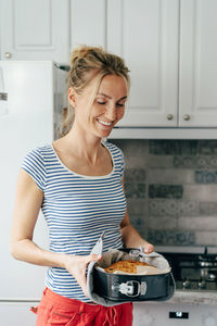 Mid adult woman holding food at home