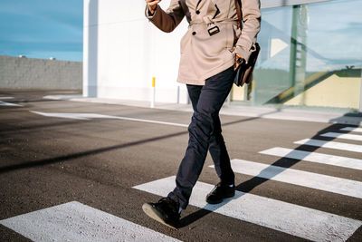 Low section of man walking on road