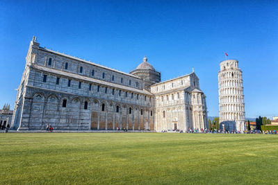 Lawn in front of building against blue sky