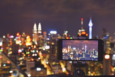 Close-up of illuminated cityscape against sky at night