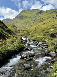 Scenic view of river amidst mountains against sky
