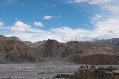 Scenic view of mountains against cloudy sky