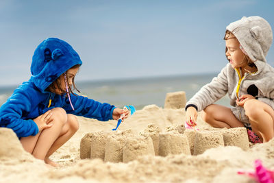 Sisters making sandcastle at beach