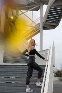 Full length of woman standing on staircase