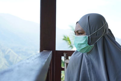 A woman wearing a mask is sitting looking at the panorama