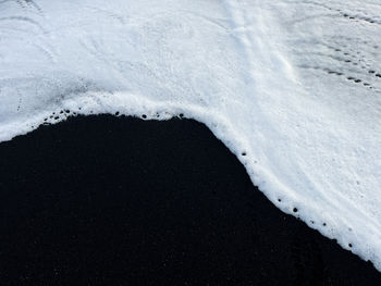 White water foam on the black sand beach in iceland