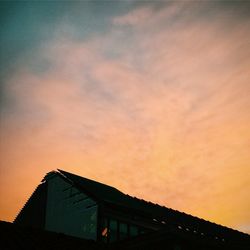 High section of building against sky at sunset