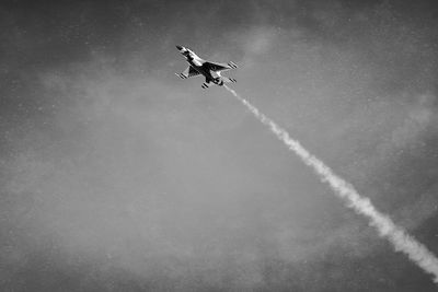 Low angle view of airplane flying against sky