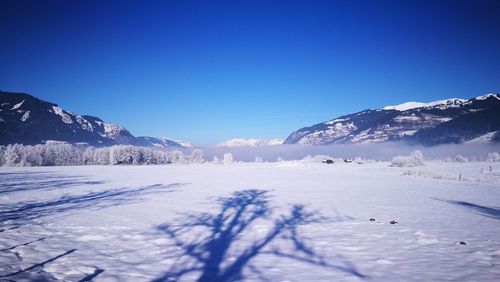 Scenic view of snowcapped mountains against clear blue sky