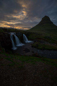 Scenic view of waterfall against sky during sunset