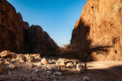 Rock formations on shore against sky