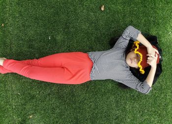 Directly above shot of girl lying on grass field