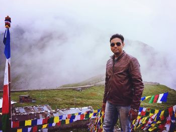 Portrait of man standing on mountain against sky