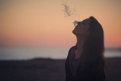 Young woman smoking cigarette during morning