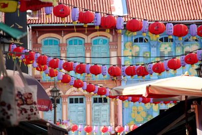 Low angle view of chinese lanterns hanging against building during new year