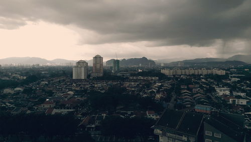 View of cityscape against cloudy sky