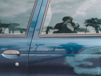 Young woman on wet car window