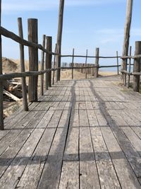 Footpath by pier on sea against sky