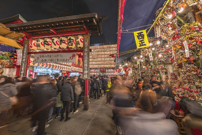 People on illuminated street in city