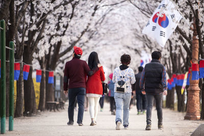 Rear view of people walking on footpath amidst cheongsachorongs