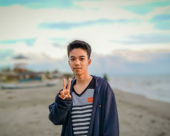 Portrait of young man standing on beach