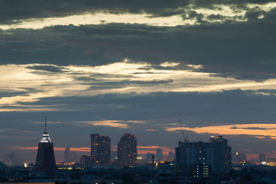 Modern buildings in city against cloudy sky