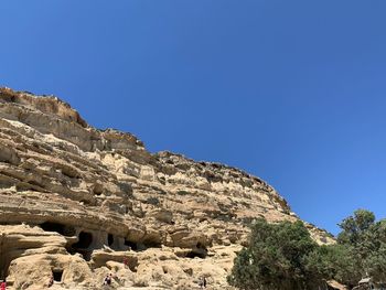 Low angle view of rock formation against clear blue sky