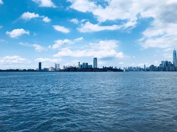 Scenic view of sea by buildings against sky