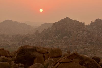 Rocks on mountain against sky during sunset