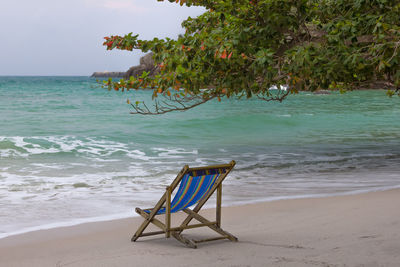 Chair on beach against sea