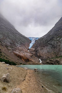 Scenic view of lake by mountain against sky