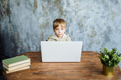 Portrait of boy using mobile phone on table