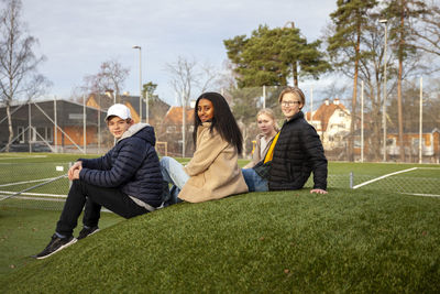 Portrait of teenage friends sitting on grass