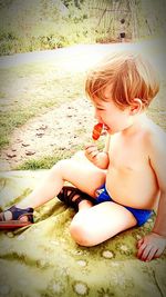 Cute boy sitting on sand