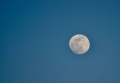 Low angle view of moon against blue sky at night