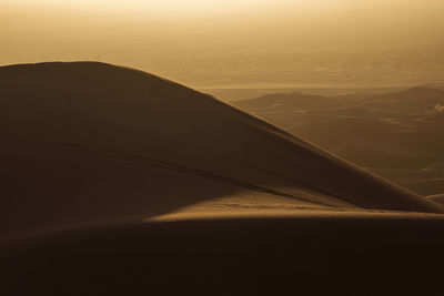 Scenic view of desert against sky during sunset