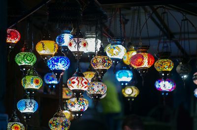 Illuminated lanterns hanging at market stall