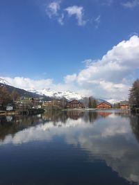 Scenic view of lake by buildings against sky