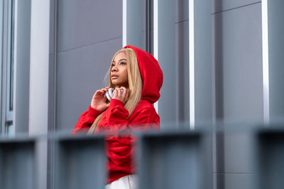 Cheerful african american woman with long blonde hair wearing sportswear and wearing headphones